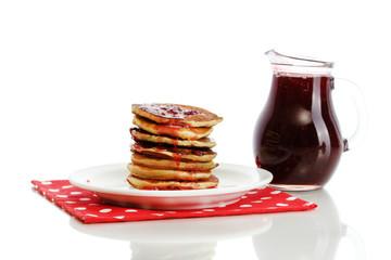 Sweet pancakes on plate with condensed milk isolated on white