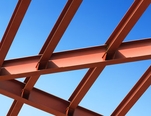 Steel beams against the blue sky. Fragment construction site.