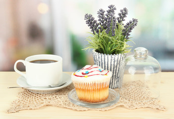 Cupcake on saucer with glass cover, on bright background