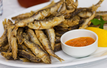 Fried fresh sprat fish with souce. Good seafood.;