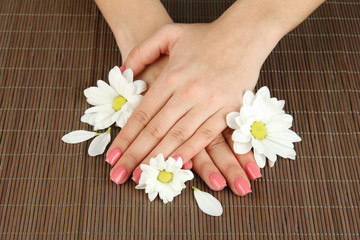 Fototapeta na wymiar Woman hands with pink manicure and flowers,