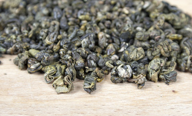 Dry green tea on wooden background