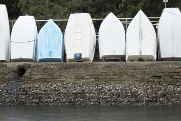 Row boats on a harbour wall