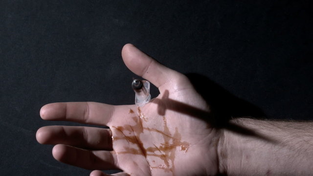 Hand holding leaking syringe dropping dead