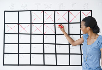 Black woman marking the days off calendar