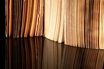 Open old book with vintage pages reflected