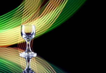 Glass of alcohol on disco background, party