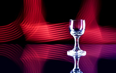 Glass of alcohol on disco background, party
