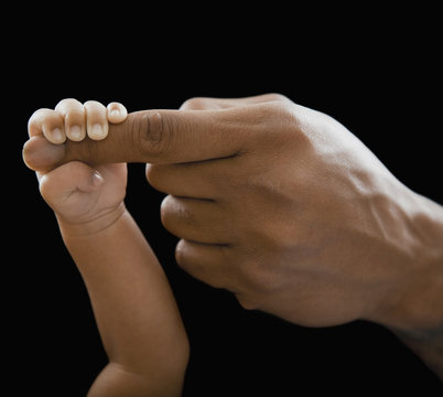 Father holding hands with newborn baby - Powered by Adobe