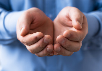 A man holds a handful, hands together, asks