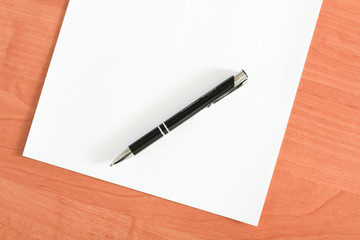 Blank sheet of paper and a pen on the table