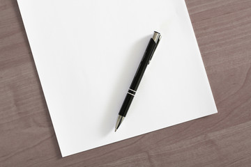 Blank sheet of paper and a pen on the table