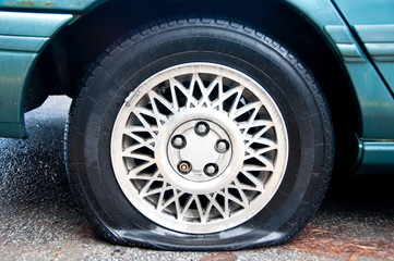 Fototapeta na wymiar Flat tire on a blue car