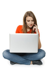 Fototapeta premium Young woman sitting on the floor using her laptop