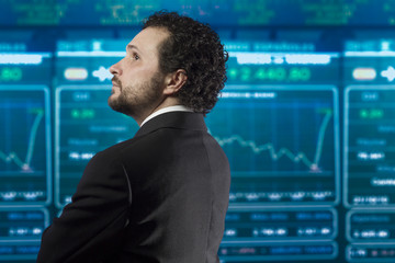 businessman with beard and black suit in the stockmarket, back