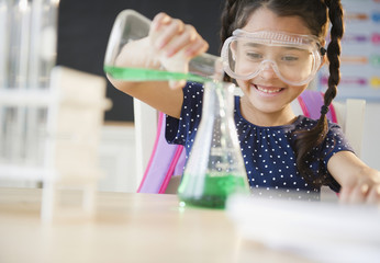 Girl pouring liquid in chemistry class