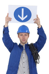 Electrician holding a one way sign