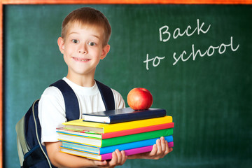 Cute student is holding books and apple