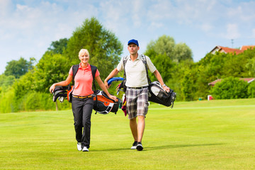 Young sportive couple playing golf on a course