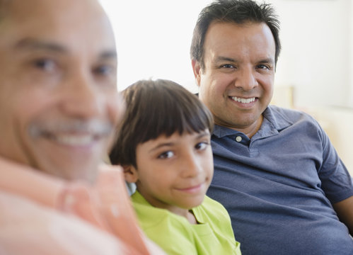 Smiling Hispanic grandfather, father and son