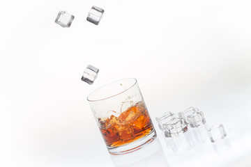Whiskey on the rocks splashed by falling ice cubes
