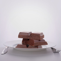 Chocolate bars stack on plate.