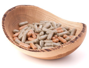 Herbal drug capsules in wooden plate. Alternative medicine conce
