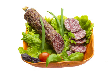 Ripe salami with salad, basil, onion and tomato
