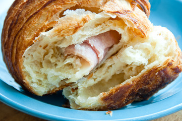Ham and cheese croissant on a blue plate