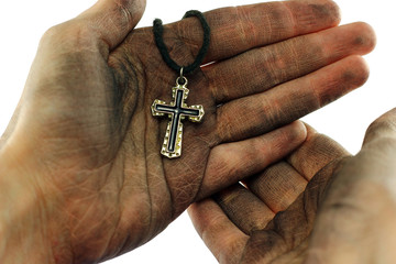 Dirty hands holding cross