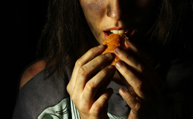 Poor dirty girl eating a piece of bread