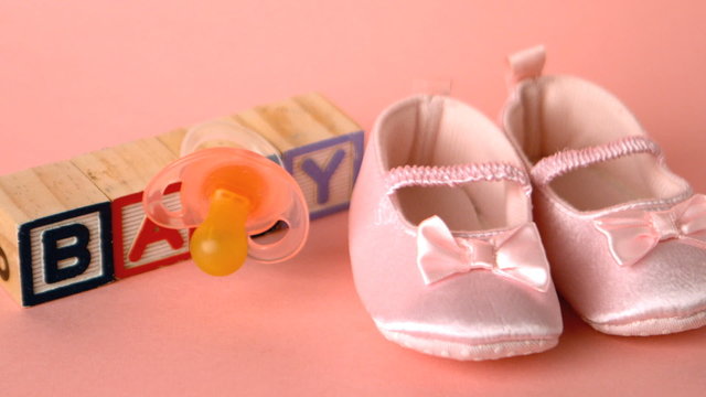 Pink soother falling onto booties