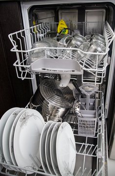 Dishwasher with white plates and glasses