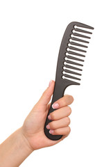 Black comb in female hand isolated on white
