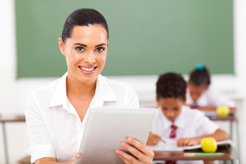 school teacher using tablet computer in classroom
