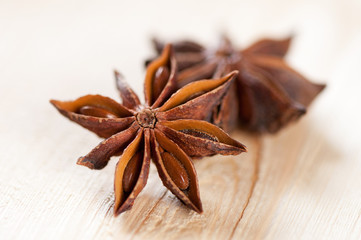 Macro shot of two star anise seeds on a wooden background