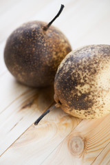 Vertical shot of two ripe chinese pears on wooden boards