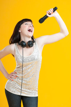 Studio portrait of a glamorous girl holding mike and singing