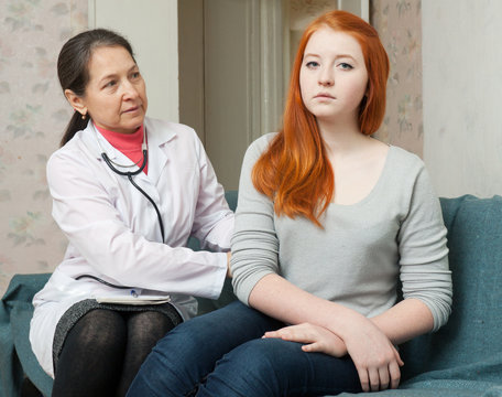 Doctor palpates behind of teenage patient