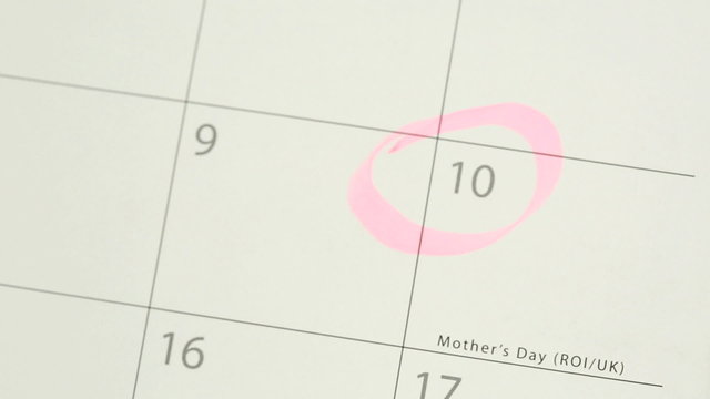 Man circling mothers day on calendar and laying down tulip