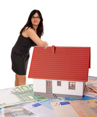 Woman based on a small house with banknotes