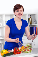young woman preparing healthy salad in her modern kitchen