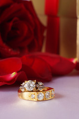 Golden diamond ring with gift box and red rose