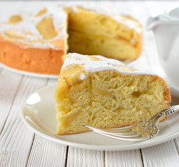 charlotte  with apples on a white table