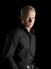 Low key portrait of young alluring man looking straight.