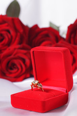 Golden diamond ring in box and red rose