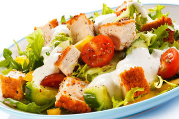 Fried chicken breast and vegetables on white background