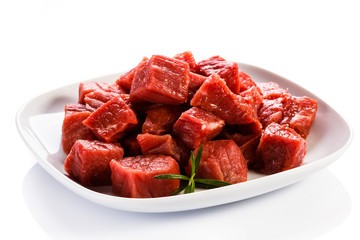 Raw beef and vegetables on white background