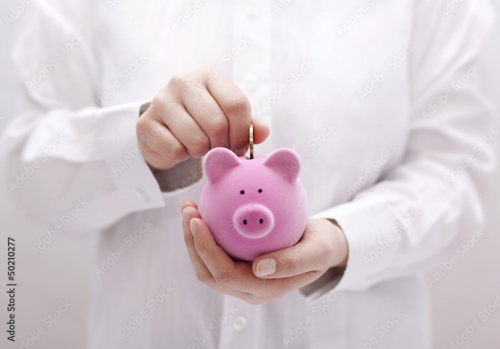 Wall mural Putting coin into the piggy bank