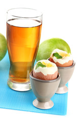 Light breakfast with boiled eggs and glass of juice, isolated
